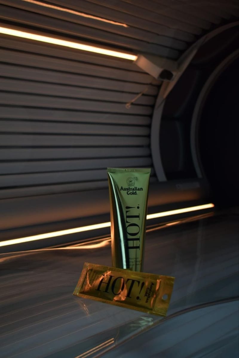 Tanning lotion tube standing on a sunbed under warm light